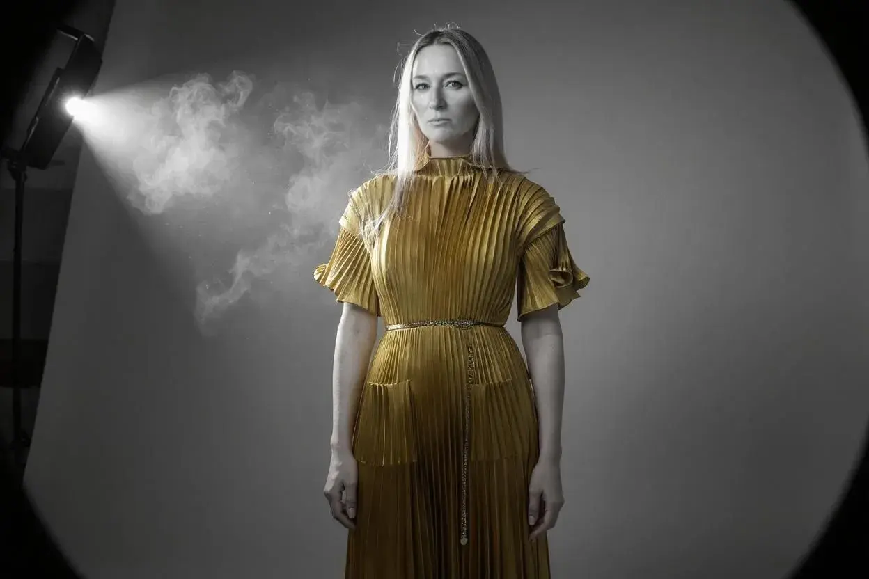 Woman in gold dress with umbrella